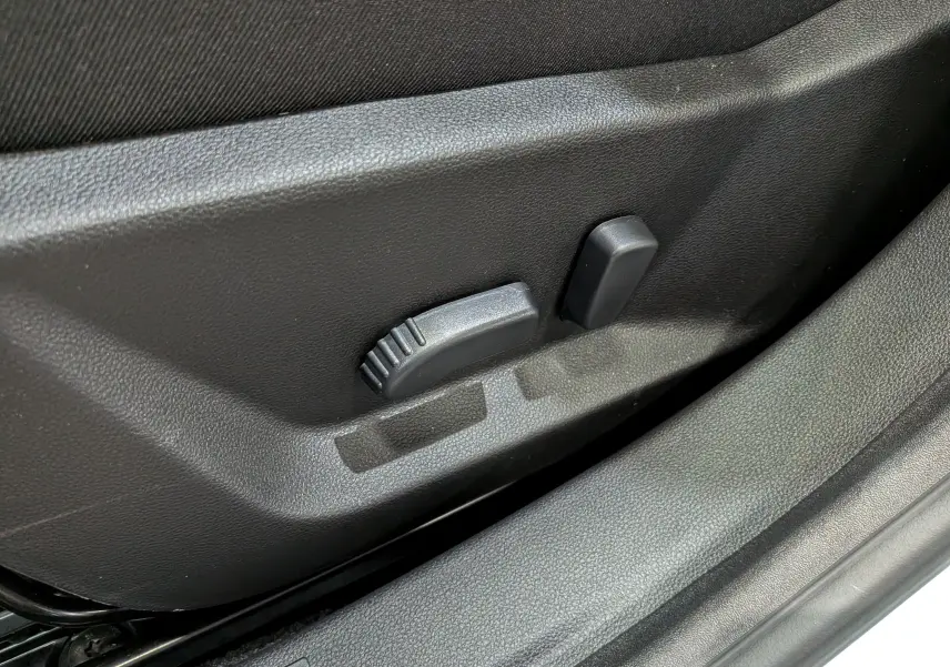 Détail du réglage électrique du siège conducteur noir dans une Dacia Bigster 2026, version Mild Hybrid blanche.