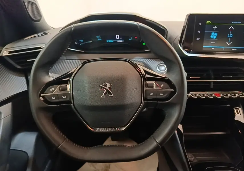 Vue rapprochée du volant cuir multifonctions noir du Peugeot E-2008 électrique Active Pack 2023 avec tableau de bord digital.