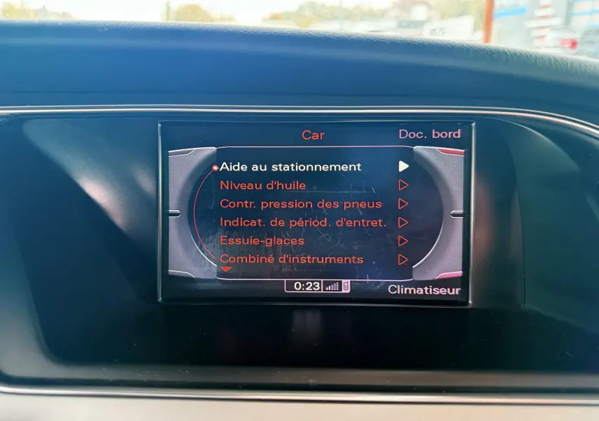 Écran central de l'Audi A5 gris 2011 affichant le menu d'aide au stationnement et contrôle des pneus.