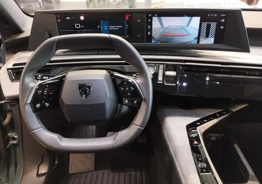 Vue intérieure du tableau de bord du Peugeot 5008 2025, volant compact cuir et double écran HD panoramique.
