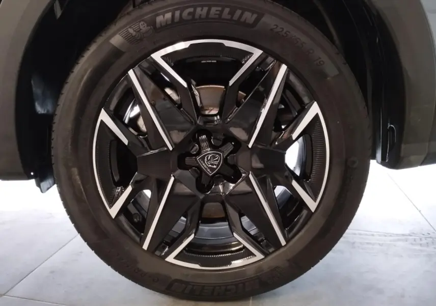 Gros plan sur la jante alliage 19'' diamantée noire et argentée du Peugeot 5008 Bleu Ingaro, pneu Michelin visible.