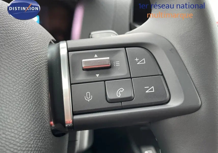 Gros plan sur les commandes multifonctions du volant gris foncé de la Citroën C4 2024 finition MAX.
