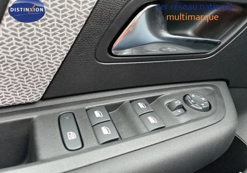 Gros plan sur la commande des vitres et la poignée intérieure côté gauche d'une Citroën C4 gris platinium métal.