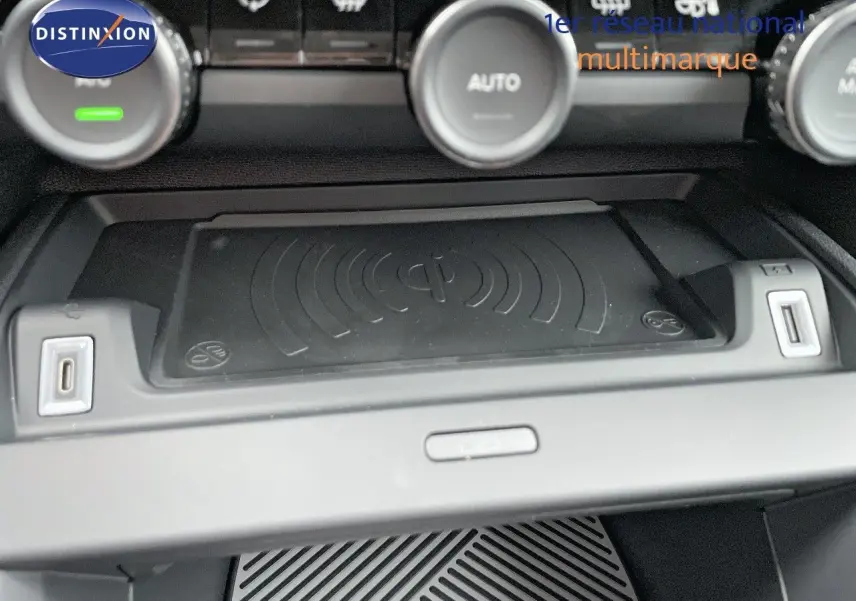 Gros plan sur la console centrale de la Citroën C4 2024, mettant en valeur le chargeur sans fil et les ports USB.