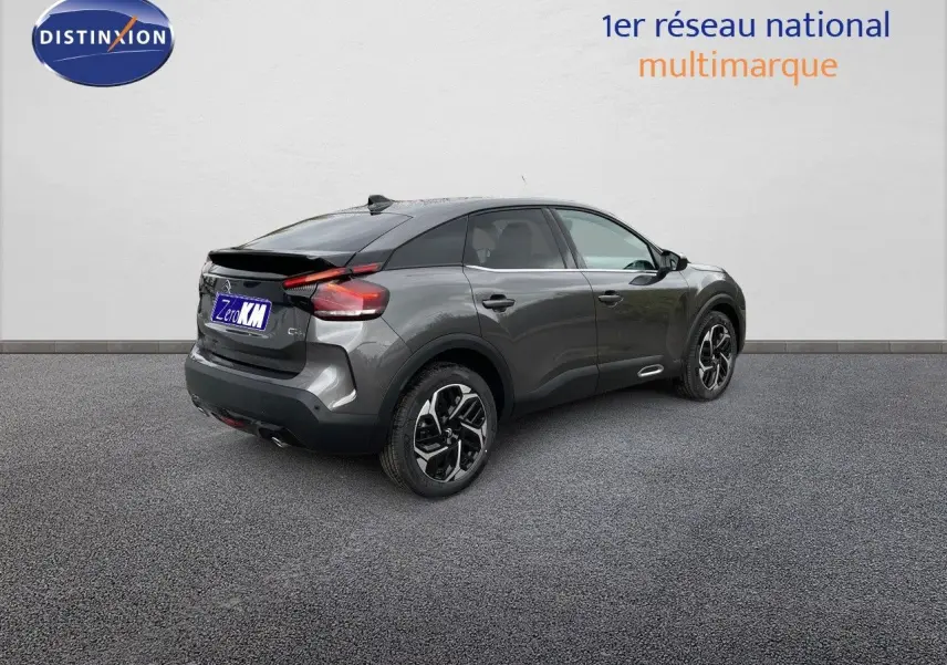 Vue 3/4 arrière droite d'une Citroën C4 2024 gris platinium métal avec jantes bi-ton et feux LED distinctifs.