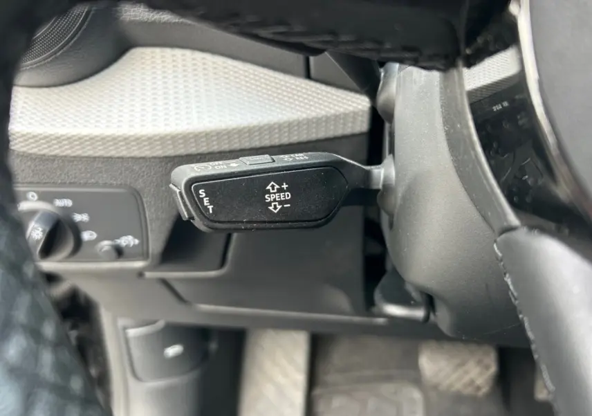 Le levier de régulateur de vitesse noir sur le côté gauche du volant d’un Audi Q2 35 TFSI 2023.