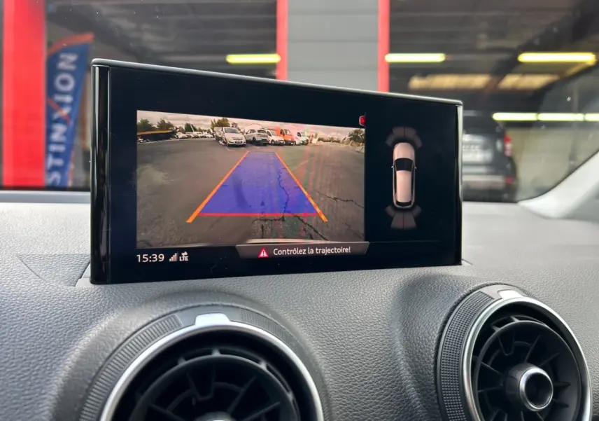 Écran central de l'Audi Q2 noir 2023 montrant la caméra de recul avec guidage de trajectoire en parking.