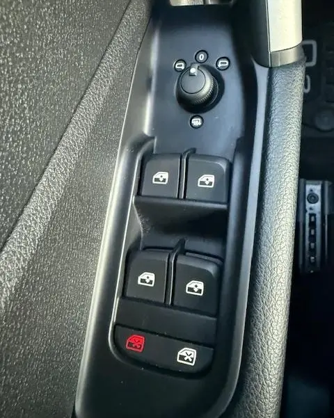 Gros plan sur les commandes de lève-vitres et rétroviseurs noirs côté conducteur de l'Audi Q2 35 TFSI 150 S Line 2023.