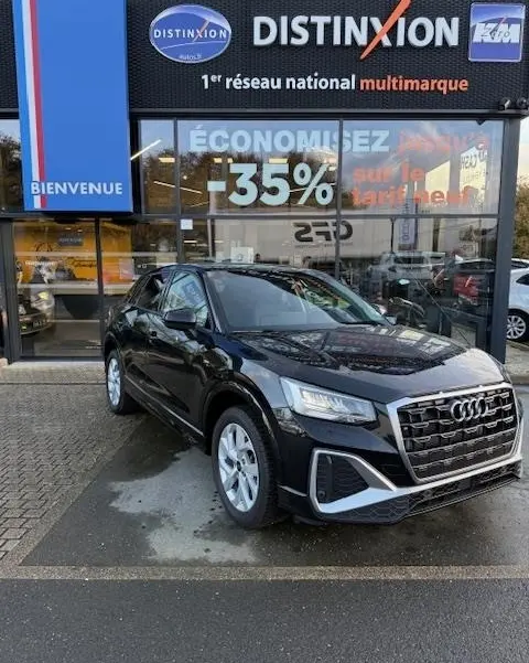 Audi Q2 35 TFSI S Line noir vue 3/4 avant, calandre distinctive et phares LED, devant concession multimarque.