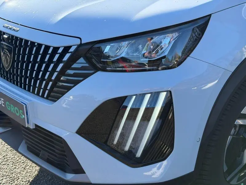 Gros plan sur l’avant droit gris Selenium du Peugeot 2008 2024, mettant en valeur les phares LED et la calandre distinctive.