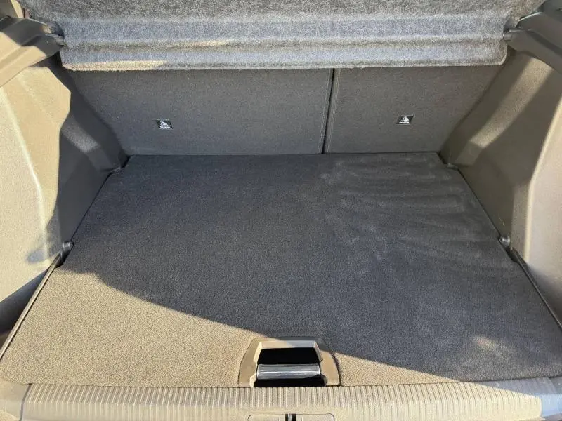 Vue intérieure du coffre spacieux et propre du Peugeot 2008 2024 gris, avec plancher de coffre mobile visible.