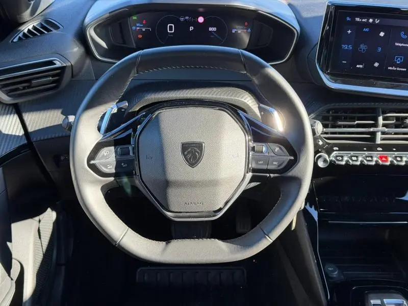 Vue rapprochée du volant multifonction noir et du tableau de bord numérique du Peugeot 2008 gris 2024.