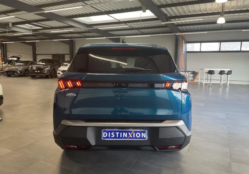 Vue arrière d’un Peugeot 5008 Bleu Obsession avec feux arrière LED 3 griffes et bandeau noir laqué en showroom.
