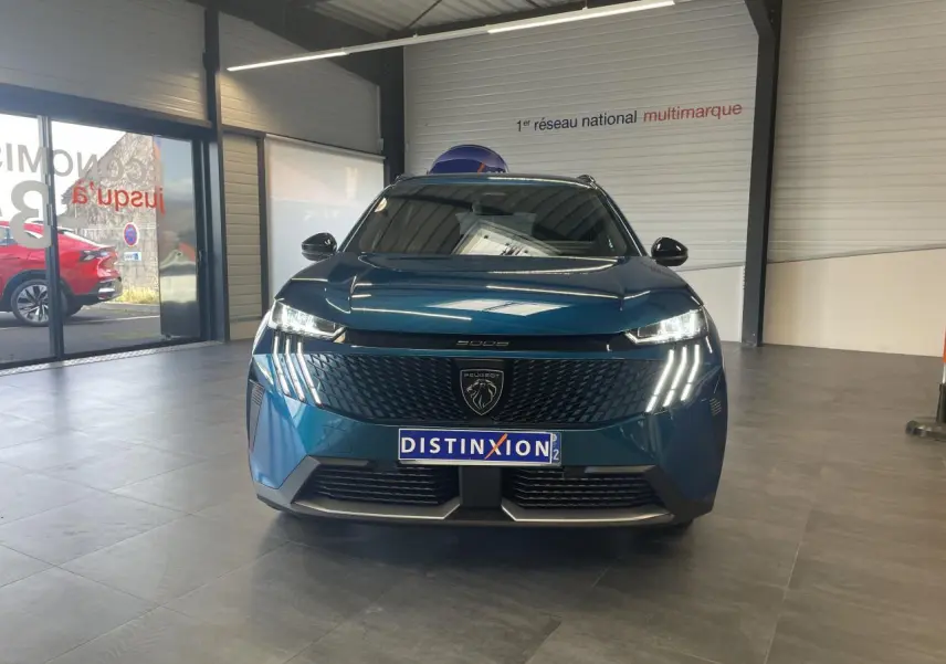 Vue avant frontale du Peugeot 5008 bleu Obsession avec calandre noire et feux LED à griffes distinctifs.