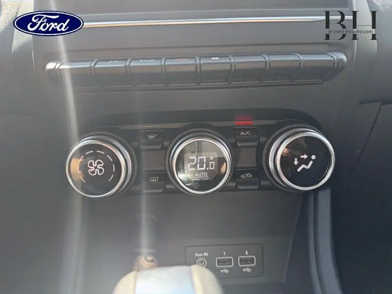 Gros plan sur la console centrale du Renault Captur gris Cassiopée, montrant les commandes de climatisation et ports USB.