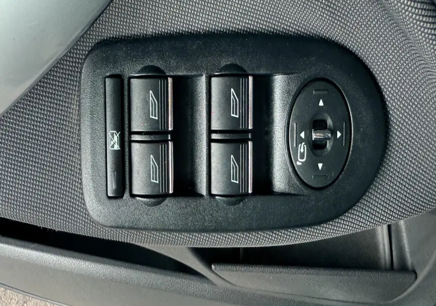 Panneau de commandes des vitres et rétroviseurs côté conducteur du Ford Kuga blanc, intérieur tissu gris noir.