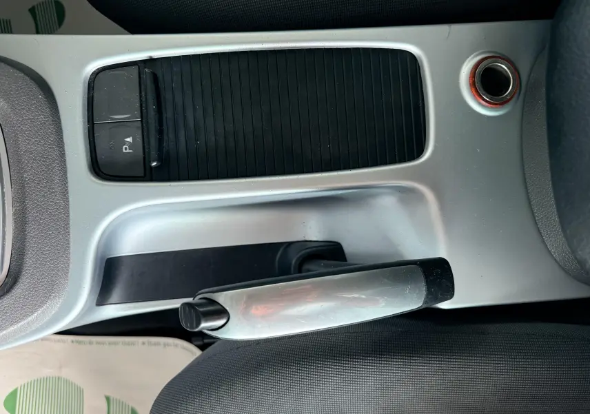 Vue rapprochée du frein à main et de la console centrale grise du Ford Kuga blanc 2012 avec intérieur tissu gris.