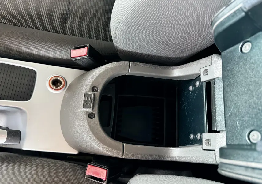 Vue plongeante sur la console centrale ouverte du Ford Kuga 2012 avec accoudoir et sièges en tissu gris noir