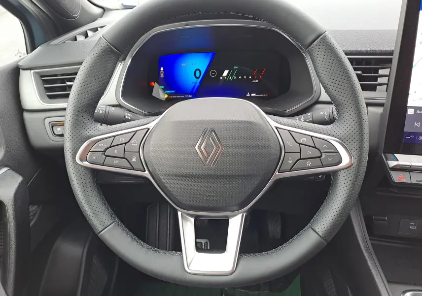 Vue rapprochée du volant noir perforé et du tableau de bord digital du Renault Symbioz 2025, version essence.