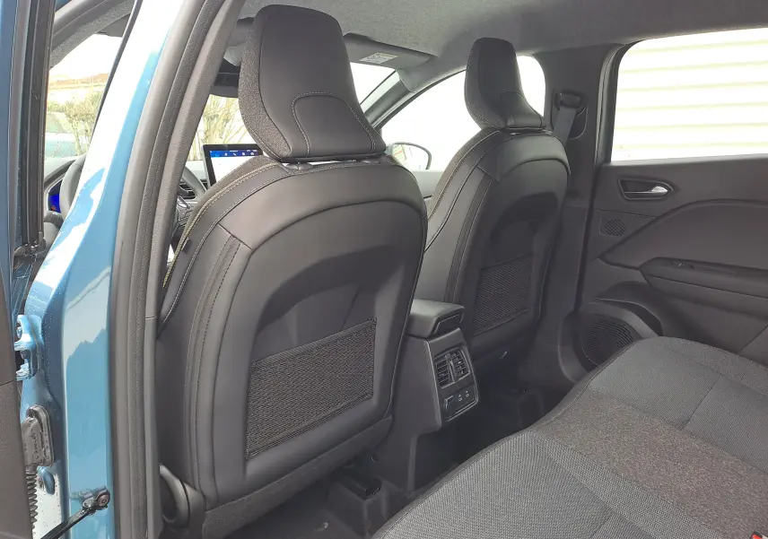 Vue arrière intérieure de la Renault Symbioz bleu mercure, montrant les sièges avant en cuir noir et la banquette arrière tissu gris.