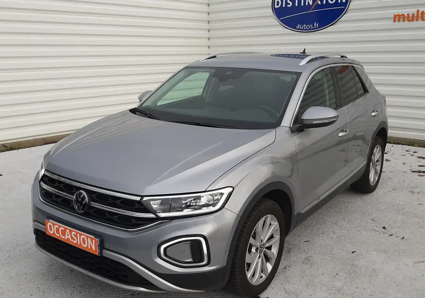 Volkswagen T-Roc gris pyrite en 3/4 avant droit, SUV compact avec phares LED et jantes alliage visibles.