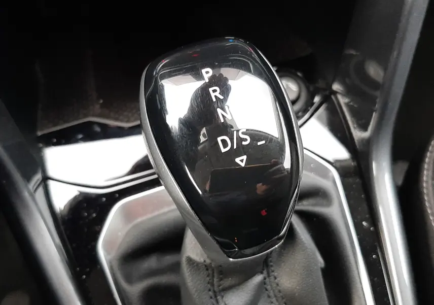 Le levier de vitesses automatique noir brillant du Volkswagen T-Roc 2023, vue rapprochée de la console centrale.