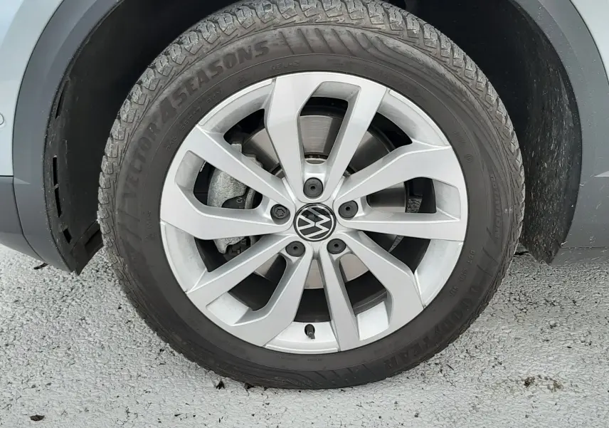 Gros plan sur la roue avant gauche d'un Volkswagen T-Roc gris pyrite avec jante alliage et pneu Goodyear.