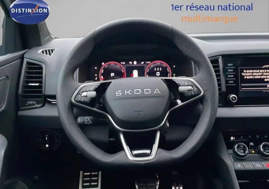 Vue intérieure centrée sur le volant SKODA KAROQ gris argent, avec tableau de bord numérique et écran multimédia.