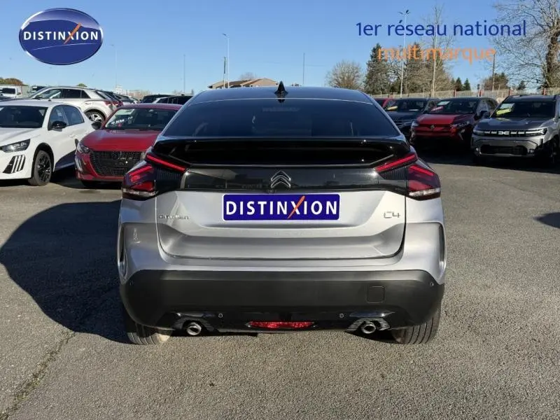 Vue arrière d'une Citroën C4 2024 gris acier avec feux LED distinctifs et double sortie d'échappement visible.