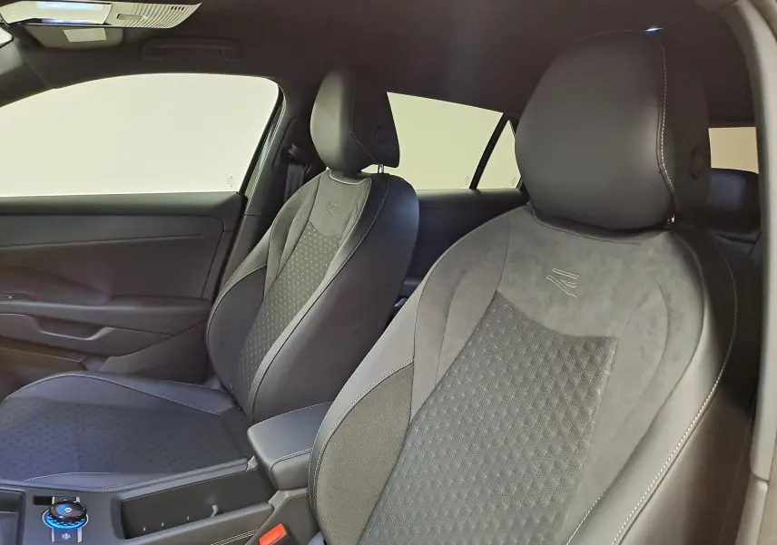 Vue intérieure côté avant droit du Volkswagen T-Roc 2026 R-Line, sièges en cuir et alcantara noirs avec surpiqûres blanches.