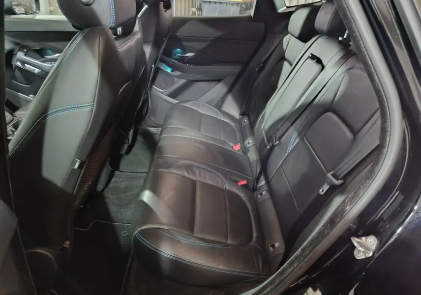 Vue intérieure côté droit des sièges arrière en cuir noir avec surpiqûres bleues d'un Jaguar E-PACE 2019.