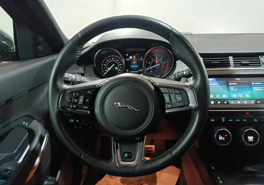 Vue intérieure centrée sur le volant cuir noir multifonctions du Jaguar E-PACE 2019 avec tableau de bord et écran tactile.