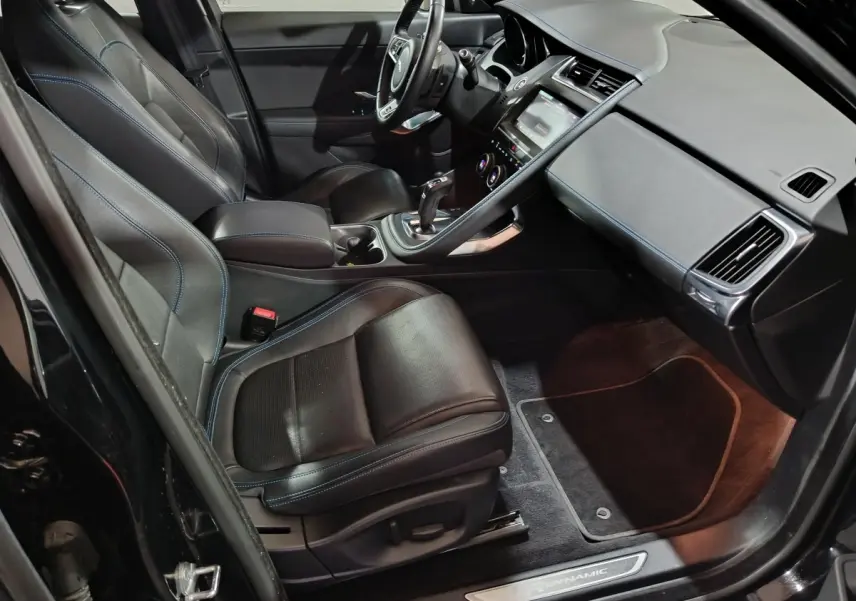 Intérieur noir du Jaguar E-PACE 2019 vu côté conducteur, avec sièges cuir et tableau de bord moderne tactile.
