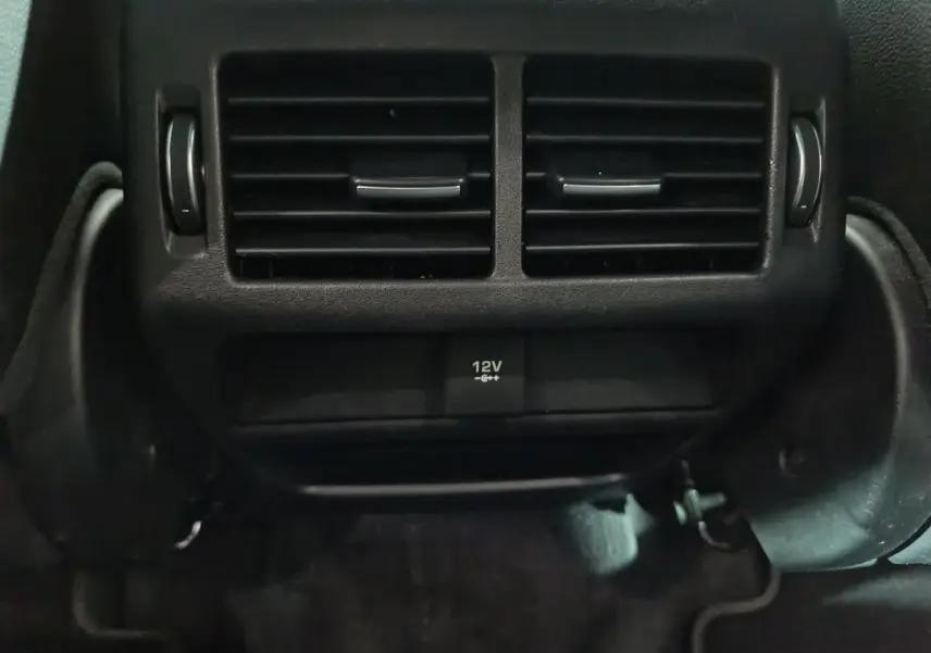 Gros plan sur la prise 12V et les aérateurs arrière noirs du Jaguar E-PACE P200 AWD R-DYNAMIC S 2019.