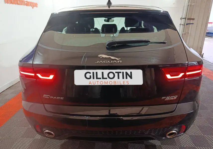 Vue arrière d'un Jaguar E-PACE noir 2019 avec feux LED allumés et double sortie d'échappement visible.