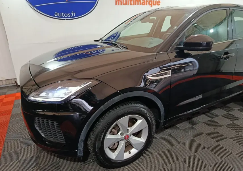 Vue 3/4 avant droit d'un Jaguar E-PACE noir brillant, mettant en valeur ses phares LED et la calandre sportive.