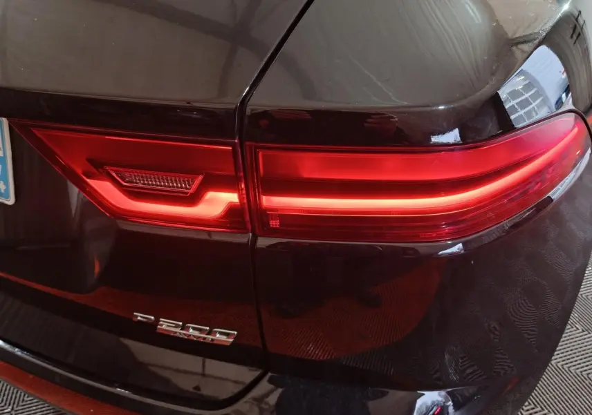 Gros plan sur le feu arrière droit rouge d'un Jaguar E-PACE noir P200 avec badge de modèle visible.