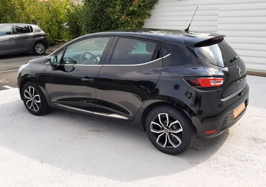 Renault Clio IV noire vue en 3/4 arrière droit, avec jantes bi-ton et feux arrière LED distinctifs.