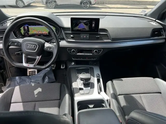 Vue intérieure avant de l'Audi Q5 gris foncé 2018, avec tableau de bord numérique et écran central tactile.