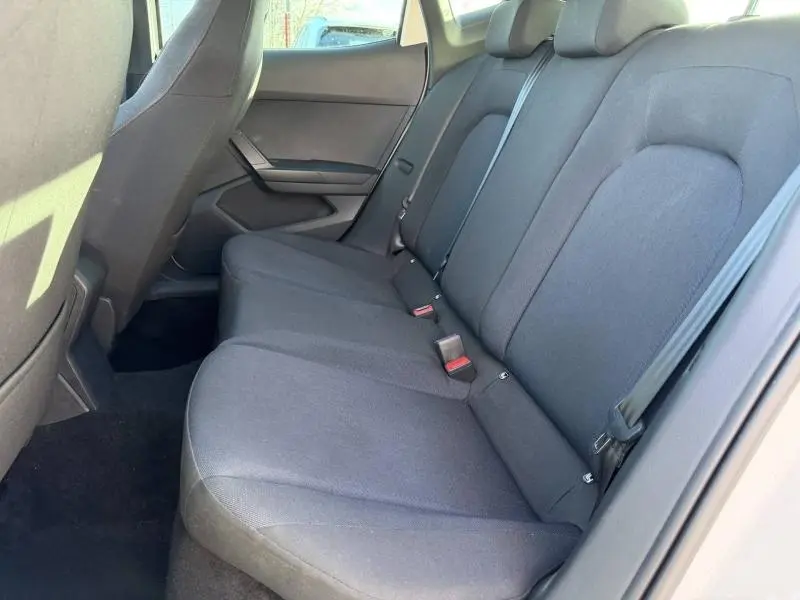 Vue latérale droite de l'intérieur arrière de la SEAT IBIZA 2025, sièges tissu gris foncé et ceinture de sécurité visible.