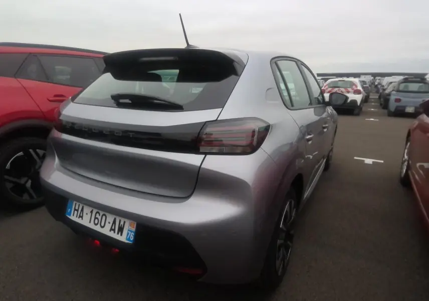 Vue 3/4 arrière droite d'une Peugeot 208 gris clair avec becquet noir brillant et feux arrière à LED signature 3 griffes.