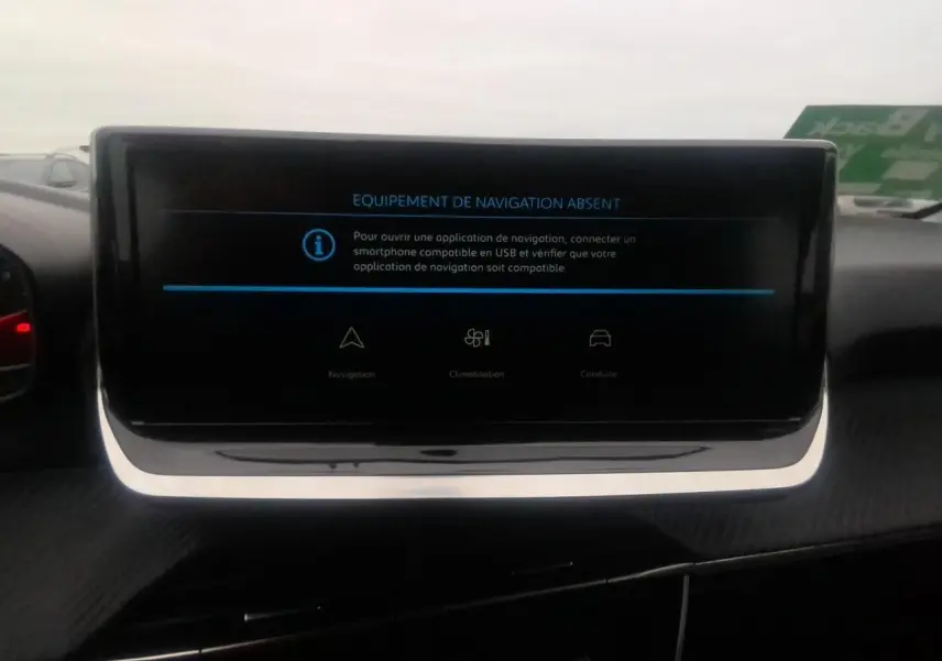 Écran tactile central du tableau de bord de la Peugeot 208 gris clair, affichant un message d'absence de navigation.