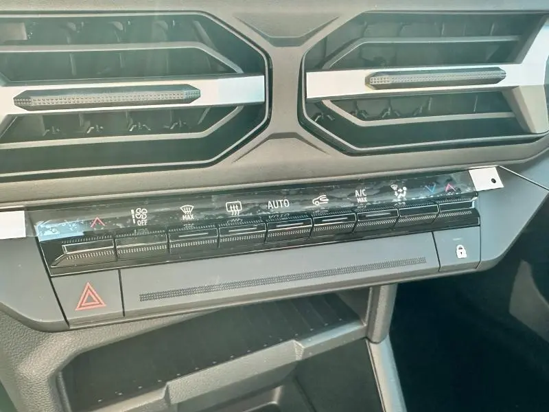 Vue rapprochée du tableau de bord du Dacia Bigster 2025 montrant les commandes de climatisation et les aérateurs noirs.