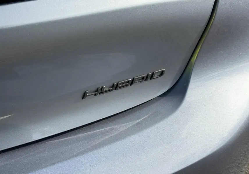 Gros plan sur l’arrière droit gris Artense d’une Peugeot 208 1.2 Hybrid avec logo "HYBRID" noir.