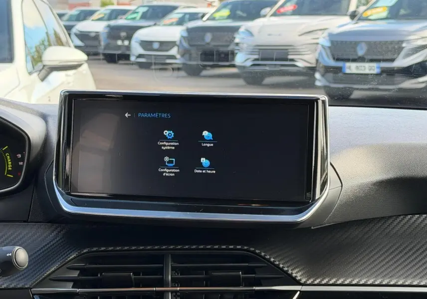 Vue intérieure centrée sur l'écran tactile du tableau de bord de la Peugeot 208 gris Artense, avec finition carbone.