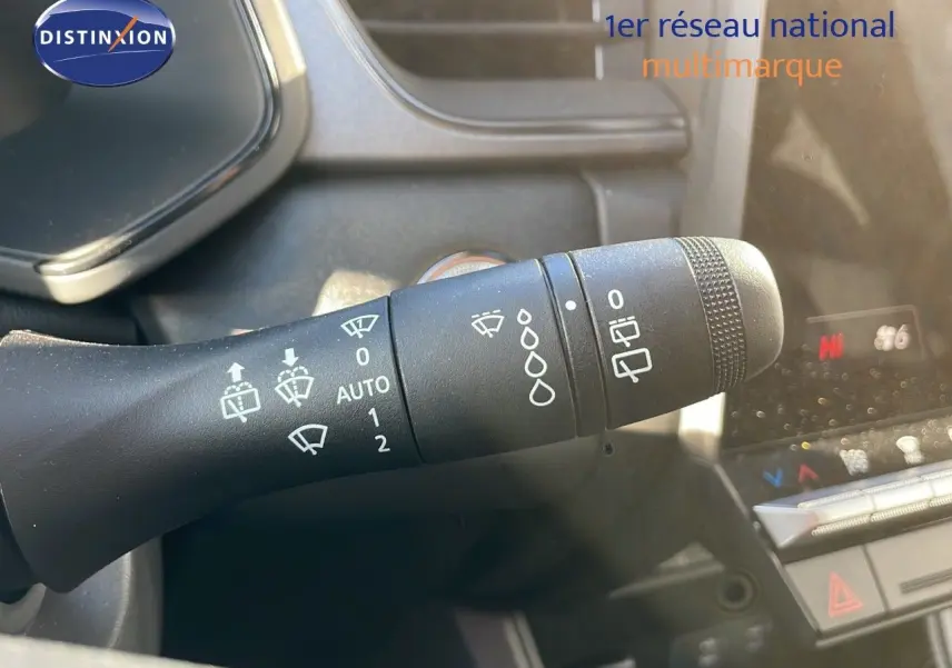 Le commodo d'essuie-glace du Renault Captur 2025 en gros plan, avec commandes blanches sur fond noir.