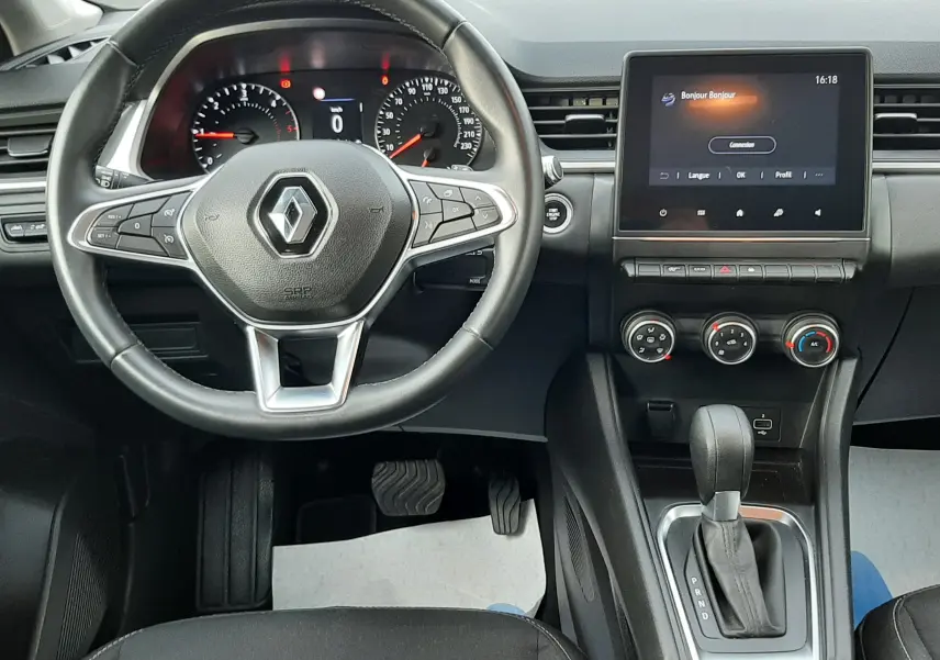 Vue intérieure avant du Renault Captur 2020, tableau de bord noir avec volant multifonction et écran tactile central allumé.