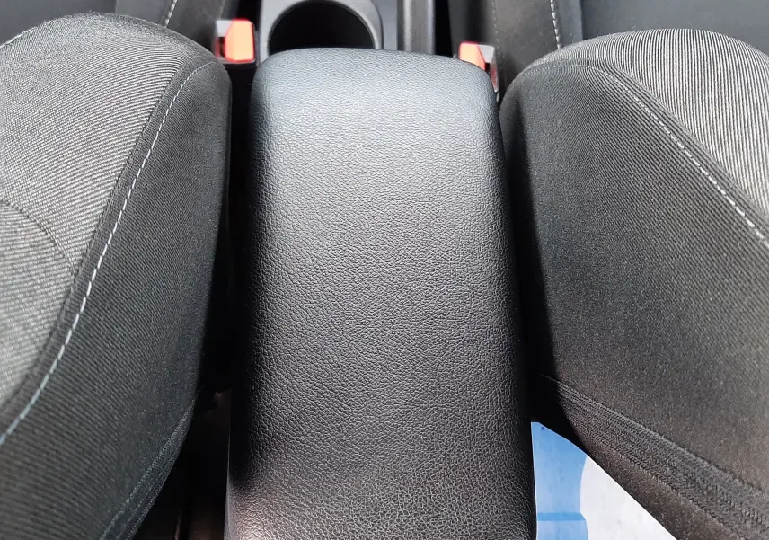 Gros plan sur l'accoudoir central noir en cuir entre les sièges avant en tissu gris du Renault Captur 2020.