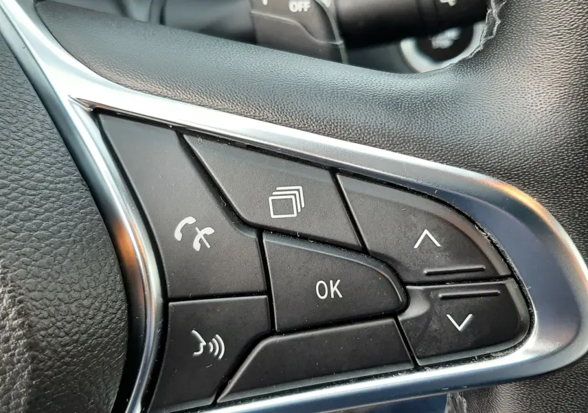 Gros plan sur les commandes multifonctions du volant à droite du Renault Captur bleu iron 2020 avec finition noire.