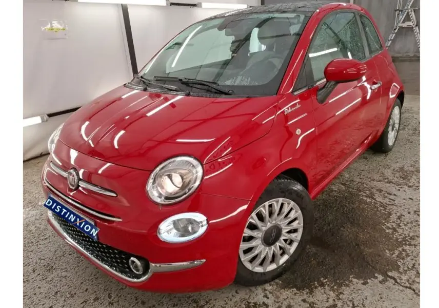 Vue 3/4 avant droite d'une Fiat 500 Dolcevita rouge brillante avec jantes spécifiques et badge distinctif sur aile avant.